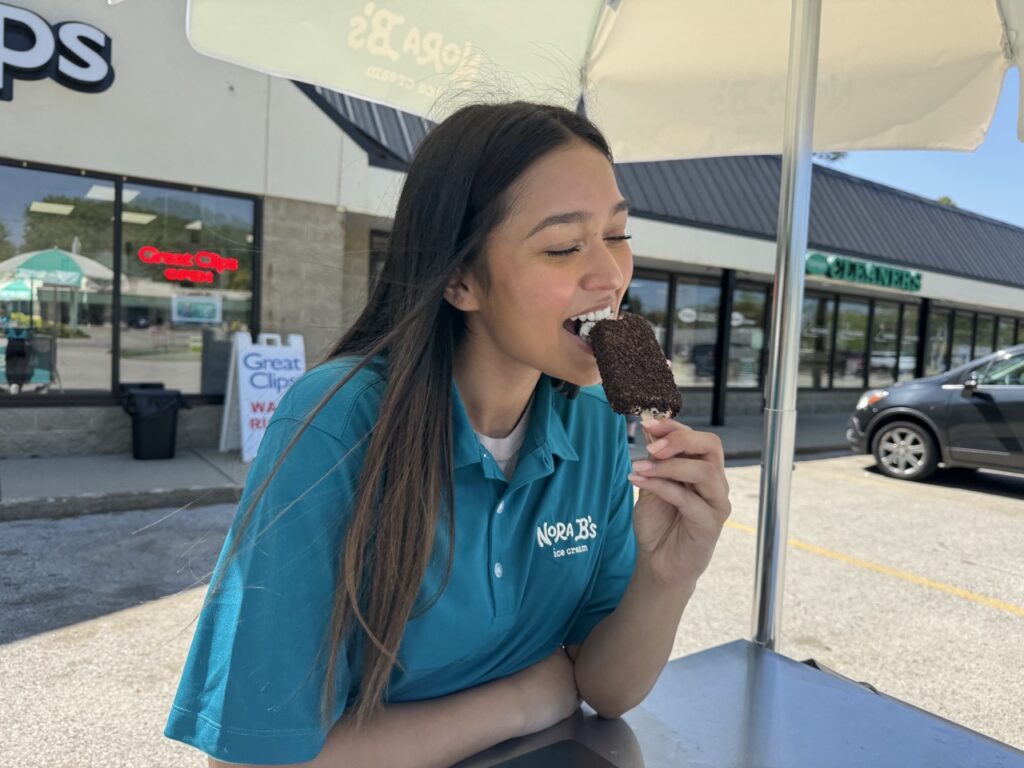 Girl eating ice cream out of nora b's ice cream cart