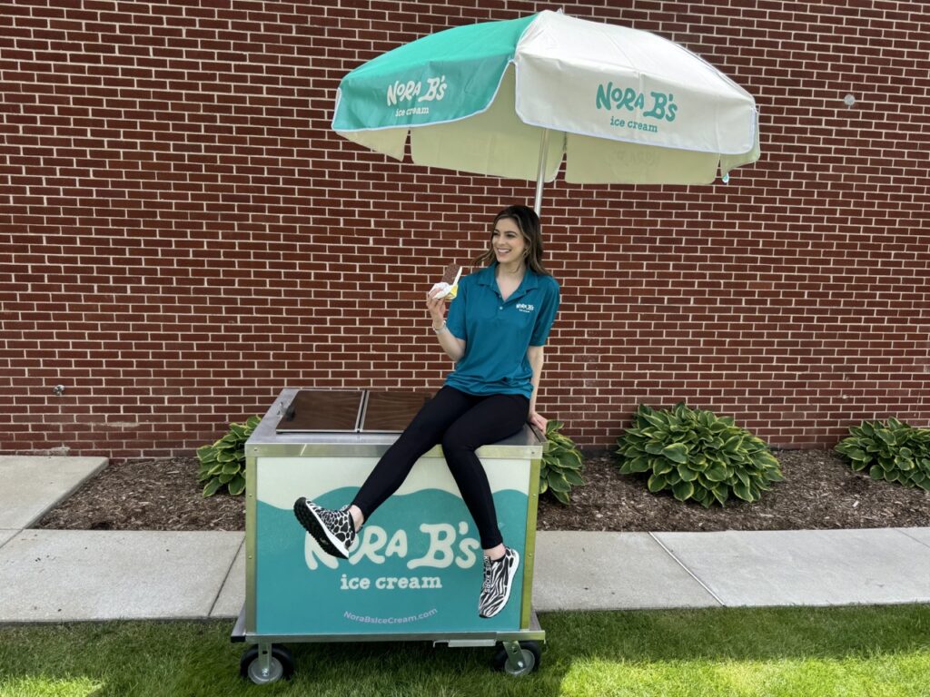 Girl sitting on Nora B's Ice cream cart rental Florida