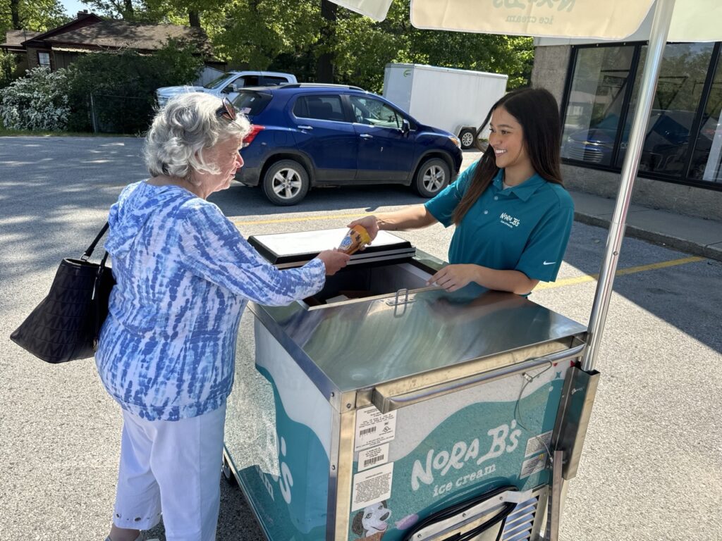 Woman getting ice cream out of nora b's ice cream cart